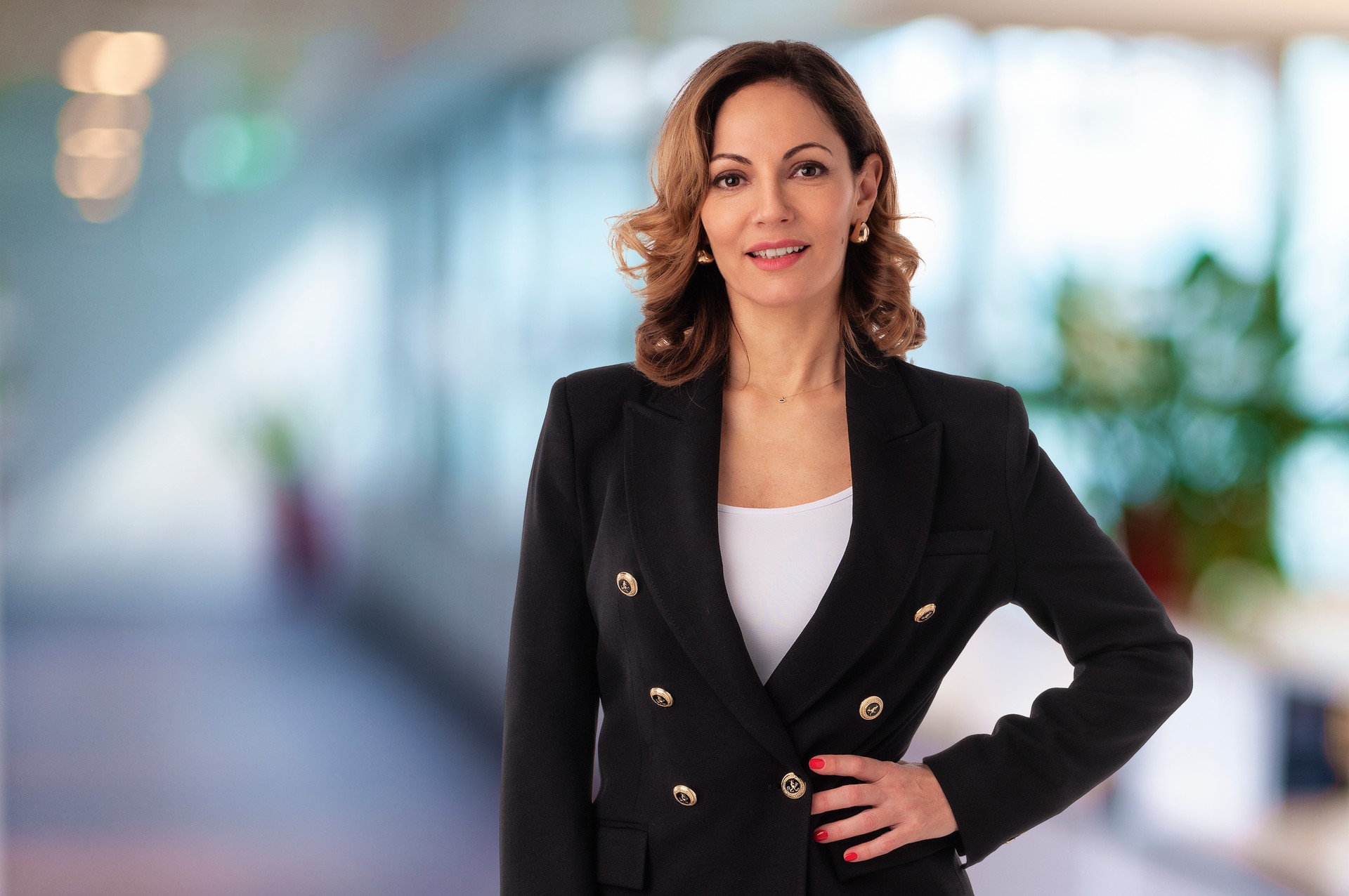 Executive blond haired businesswoman wearing black jacket and standing at the office