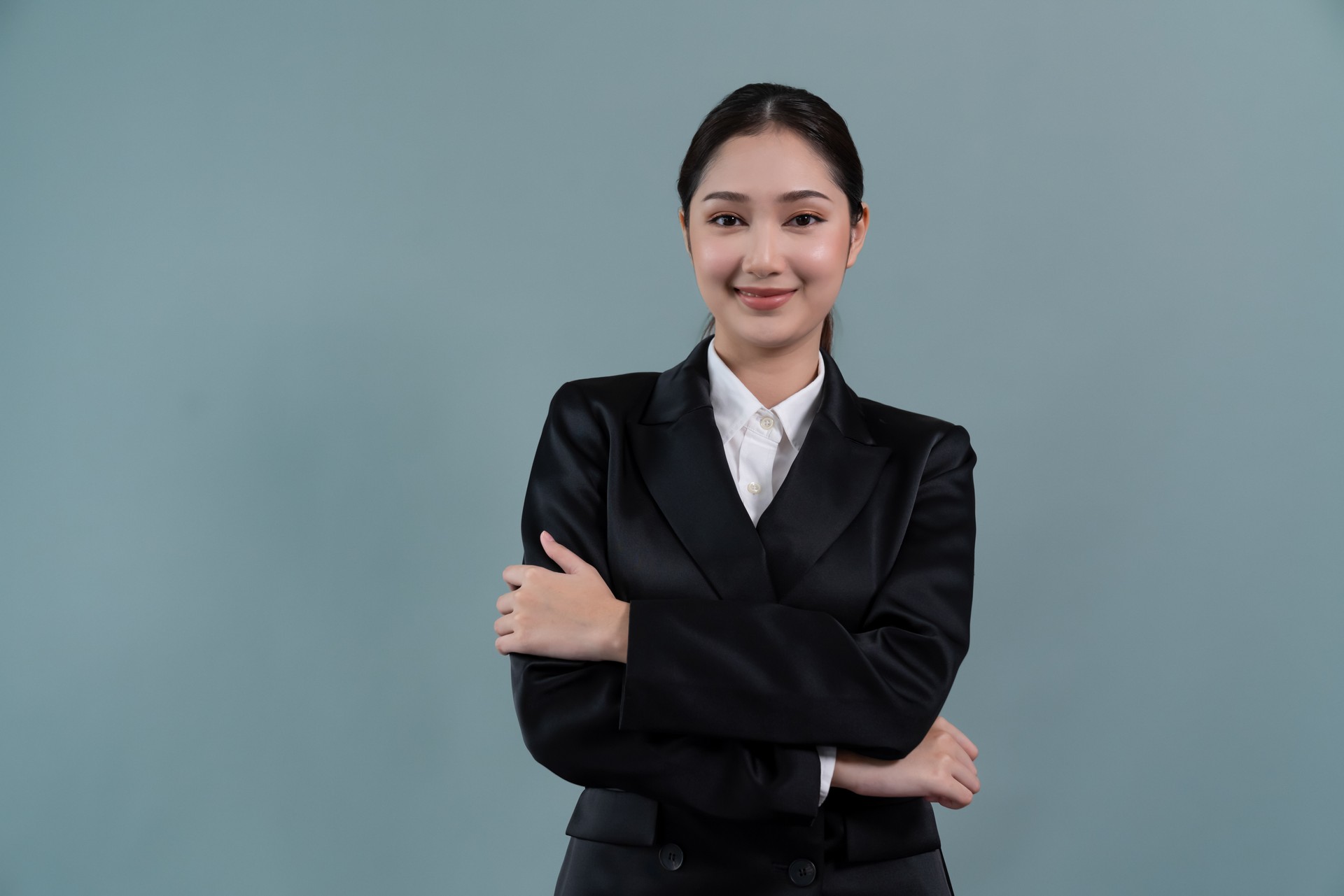 Confident young businesswoman stands on isolated background. Enthusiastic